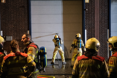 911063 Afbeelding van enkele brandweerlieden tijdens het blussen van de brand in het bedrijvenverzamelgebouw CAB-Rondom ...